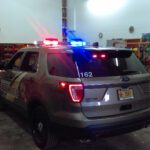 A police car with lights on parked in garage.