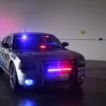 A police car with lights on parked in a garage.