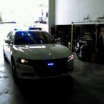 A police car parked in a garage with lights on.