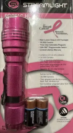 A pink PROTAC HL Handheld Flashlight Breast Cancer Support with two batteries in the package.